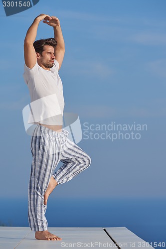 Image of young man practicing yoga