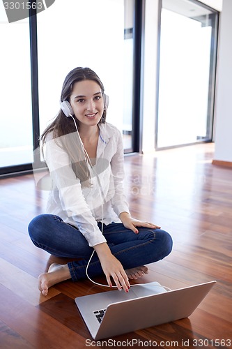 Image of relaxed young woman at home working on laptop computer