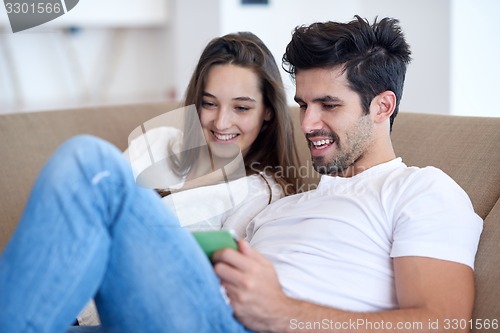 Image of couple at modern home using tablet computer