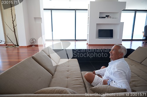 Image of Portrait of senior man relaxing in sofa