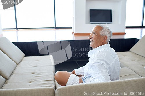 Image of Portrait of senior man relaxing in sofa