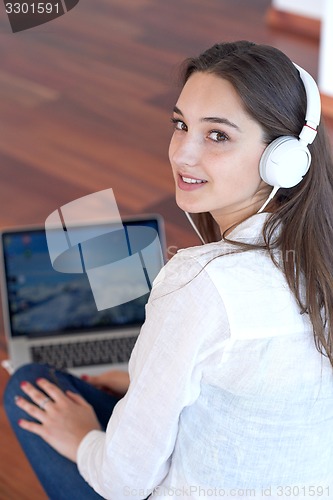 Image of relaxed young woman at home working on laptop computer