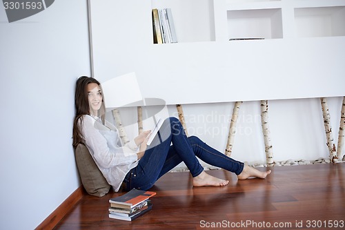 Image of relaxed young woman at home working on laptop computer