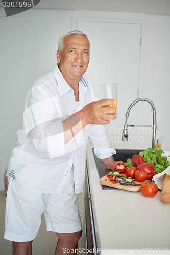 Image of man cooking at home preparing salad in kitchen