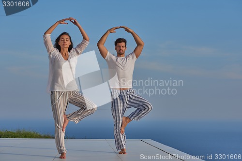 Image of young couple practicing yoga