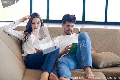 Image of couple at modern home using tablet computer