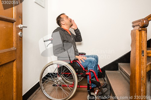 Image of man in wheelchair facing a barrier of stairs