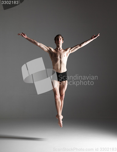 Image of The young attractive modern ballet dancer jumping on white background