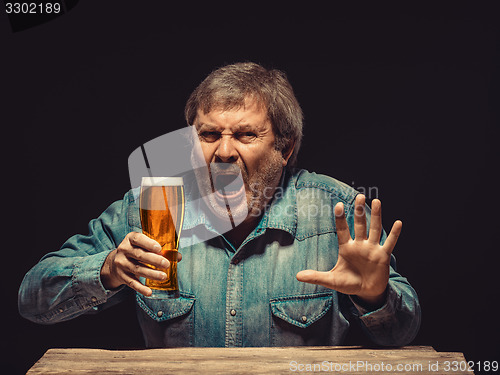 Image of The enchanted and emotional fan with glass of beer