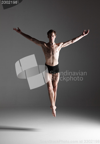 Image of The young attractive modern ballet dancer jumping on white background