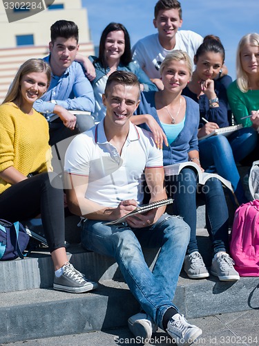 Image of students outside sitting on steps