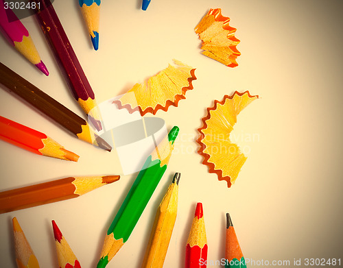 Image of several colored pencils and shavings on white background