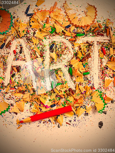 Image of art word on the background of colored pencil shavings