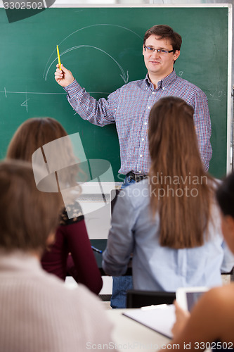 Image of Teacher in front of a chalkboard