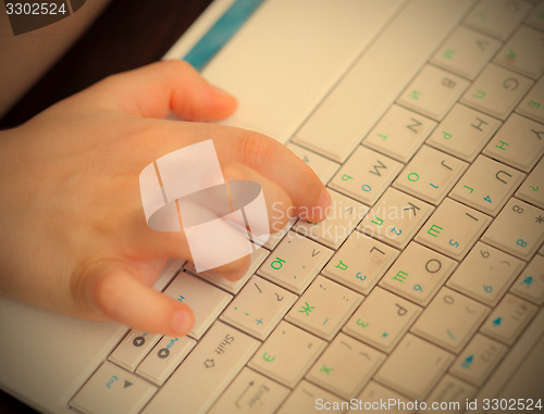 Image of child\'s hand on the laptop keyboard