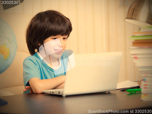 Image of smiling boy looking at a computer monitor