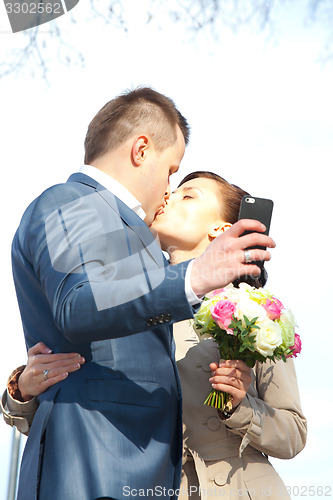 Image of beautiful bride and groom make selfie
