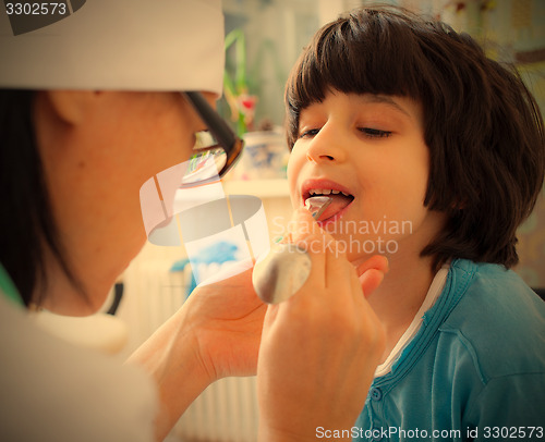 Image of doctor otolaryngologist looking boy throat