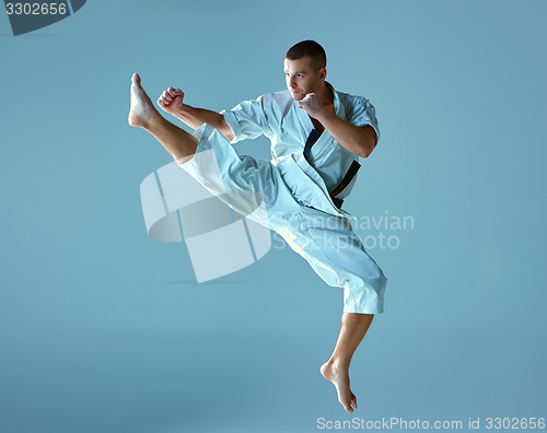 Image of Man in white kimono training karate