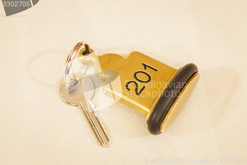 Image of Hotel Room Key lying on Bed with keyring