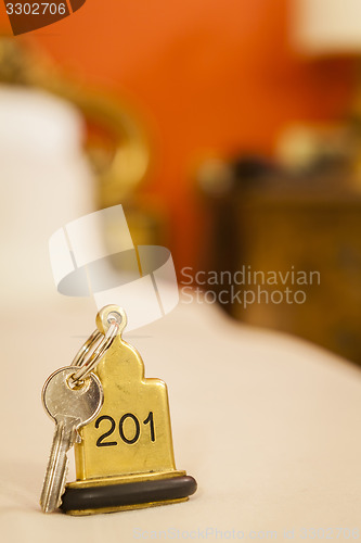 Image of Hotel Room Key lying on Bed with keyring