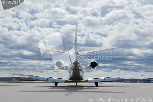 Image of Aircraft learjet Plane in front of the Airport with cloudy sky