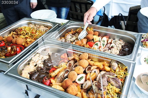 Image of cook and fried meat in lunch counter at public catering restaura