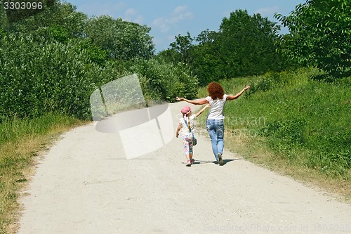 Image of Mother and daughter walking by rural road