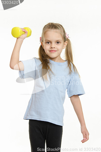 Image of The girl raised her right arm dumbbell