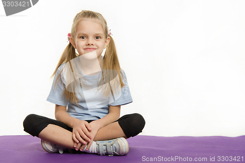 Image of Six year old girl sitting on the mat for practice