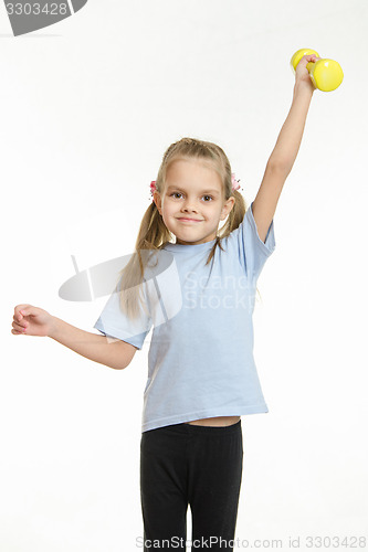 Image of Six year old girl held up a dumbbell