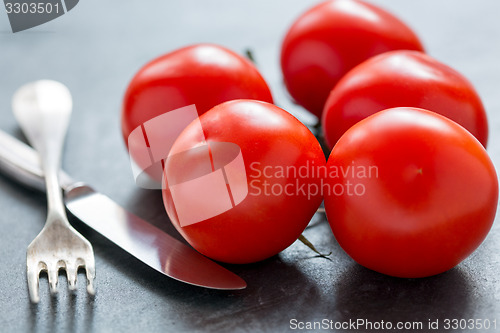 Image of Ripe tomatoes, knife and fork.