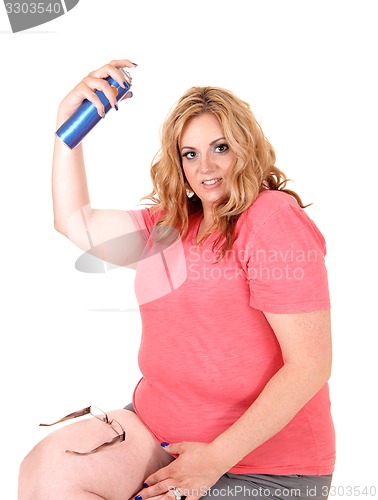 Image of Plus size woman straying hairspray on.