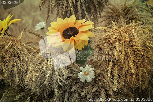 Image of Decoration of artificial flowers and ears of corn.