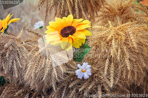 Image of Decoration of artificial flowers and ears of corn.