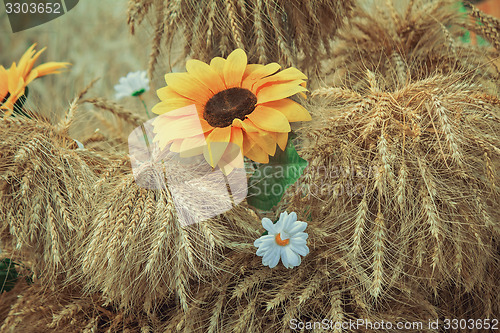 Image of Decoration of artificial flowers and ears of corn.