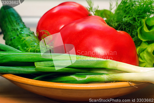Image of Fresh vegetables: tomatoes, cucumbers, onions, lettuce.