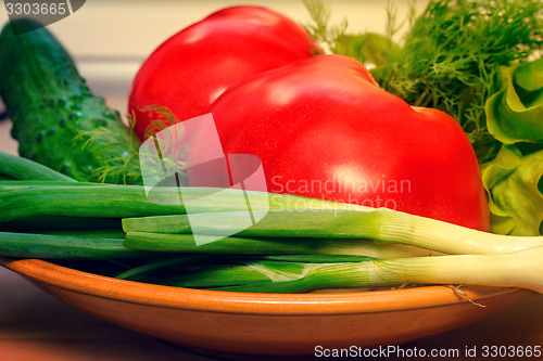 Image of Fresh vegetables: tomatoes, cucumbers, onions, lettuce.