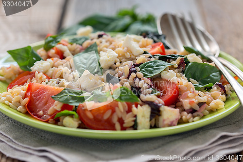 Image of Orzo pasta with basil, tomatoes and cheese.