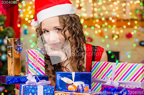 Image of Beautiful girl at a table with Christmas gifts