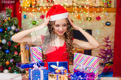 Image of Beautiful girl clutching her head when choosing a gift