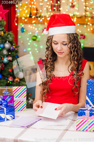 Image of She puts a postcard with Christmas greetings in an envelope