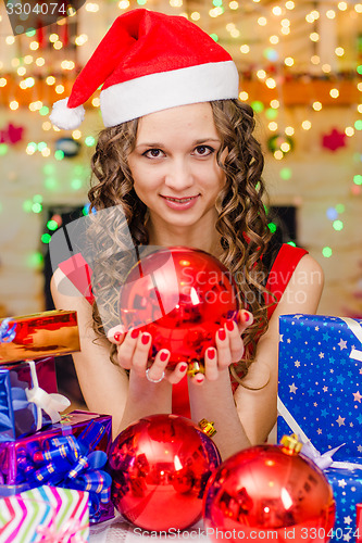 Image of The girl is holding a big Christmas ball