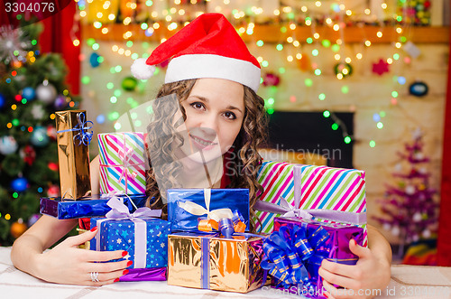 Image of Beautiful girl with a bunch of Christmas gifts