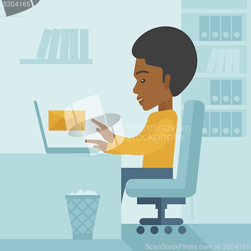 Image of Young african man sitting infront of a computer laptop.