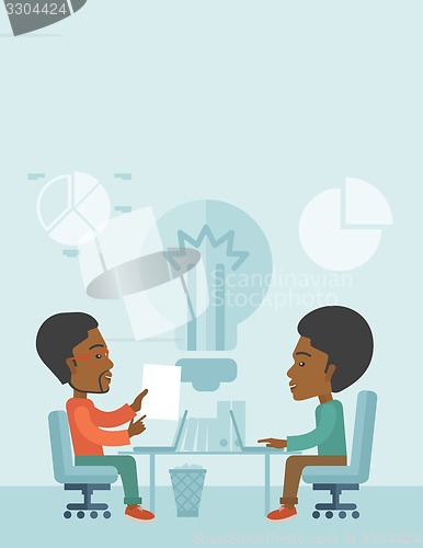 Image of Two african businessmen sitting working together.