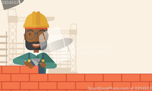 Image of Black builder man is building a brick wall.