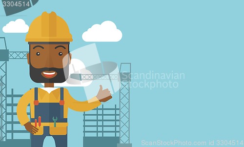 Image of Black man standing infront of construction crane tower.