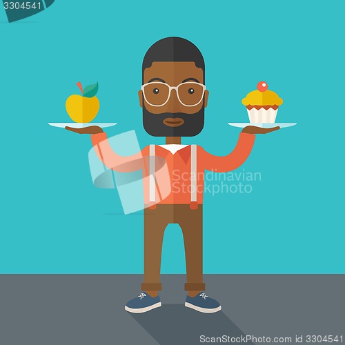 Image of Man carries with his two hands cupcake and apple.