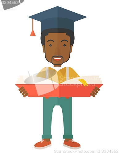 Image of Black man standing with graduation cap.